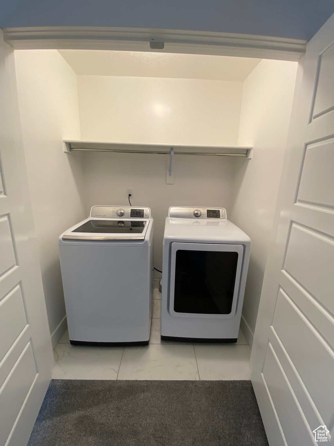 Laundry area with washer and dryer and light tile floors