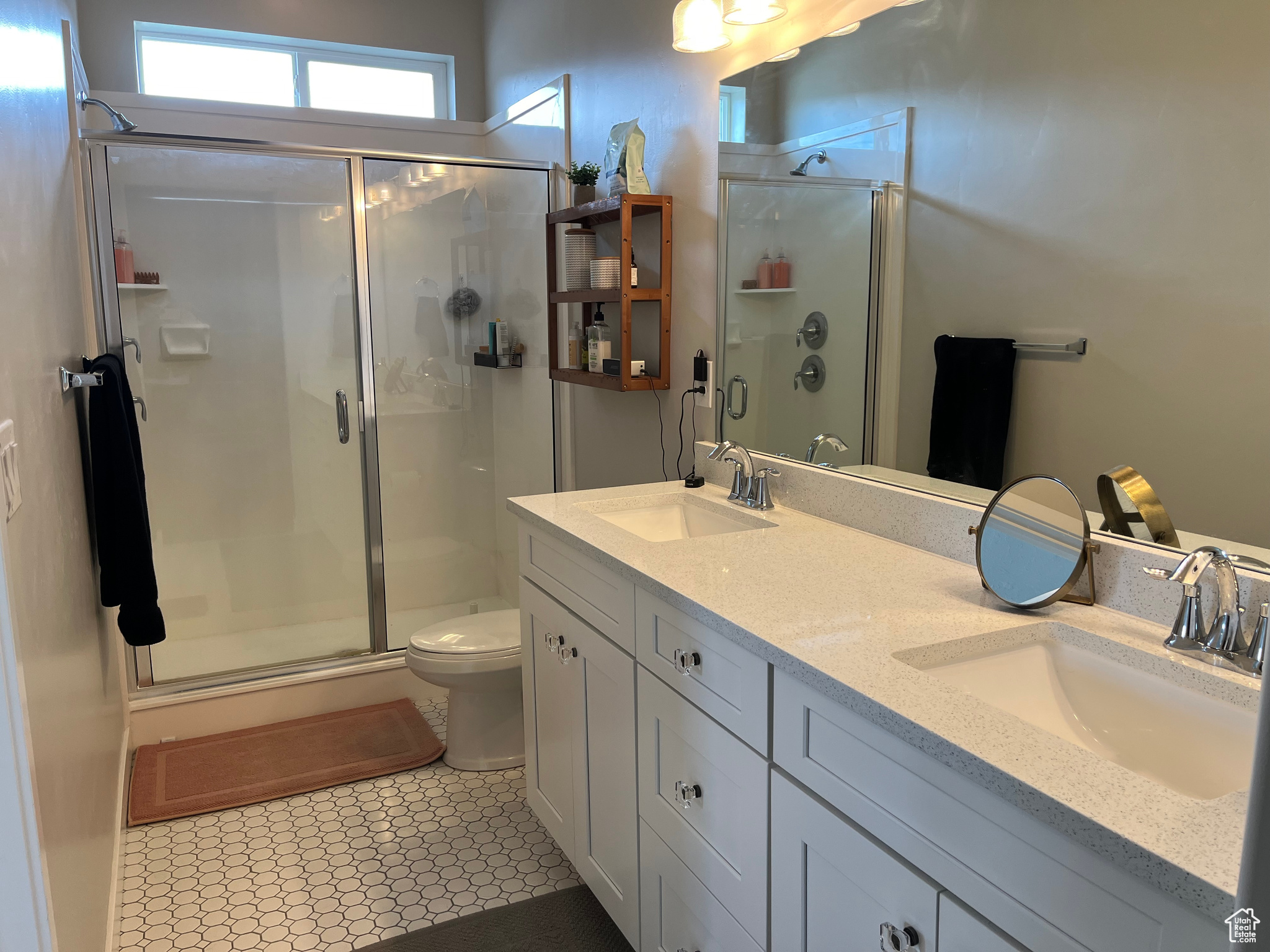 Main Bathroom with an enclosed shower, dual bowl vanity, toilet, and tile flooring