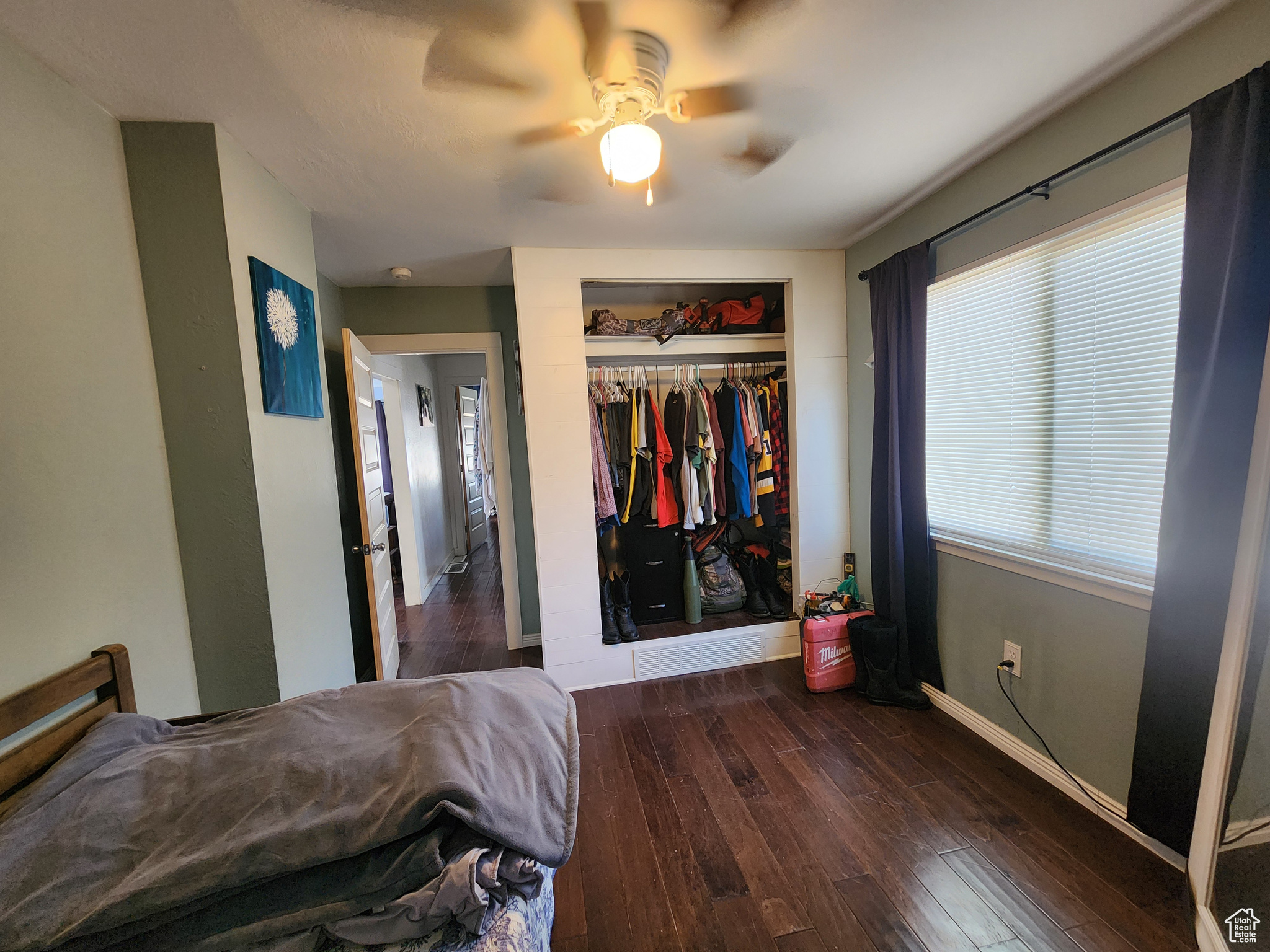 Bedroom with a closet, dark wood-type flooring, and ceiling fan