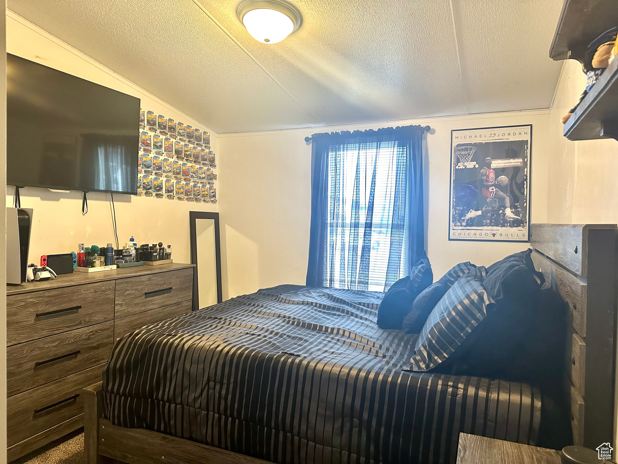 Bedroom with a textured ceiling and lofted ceiling