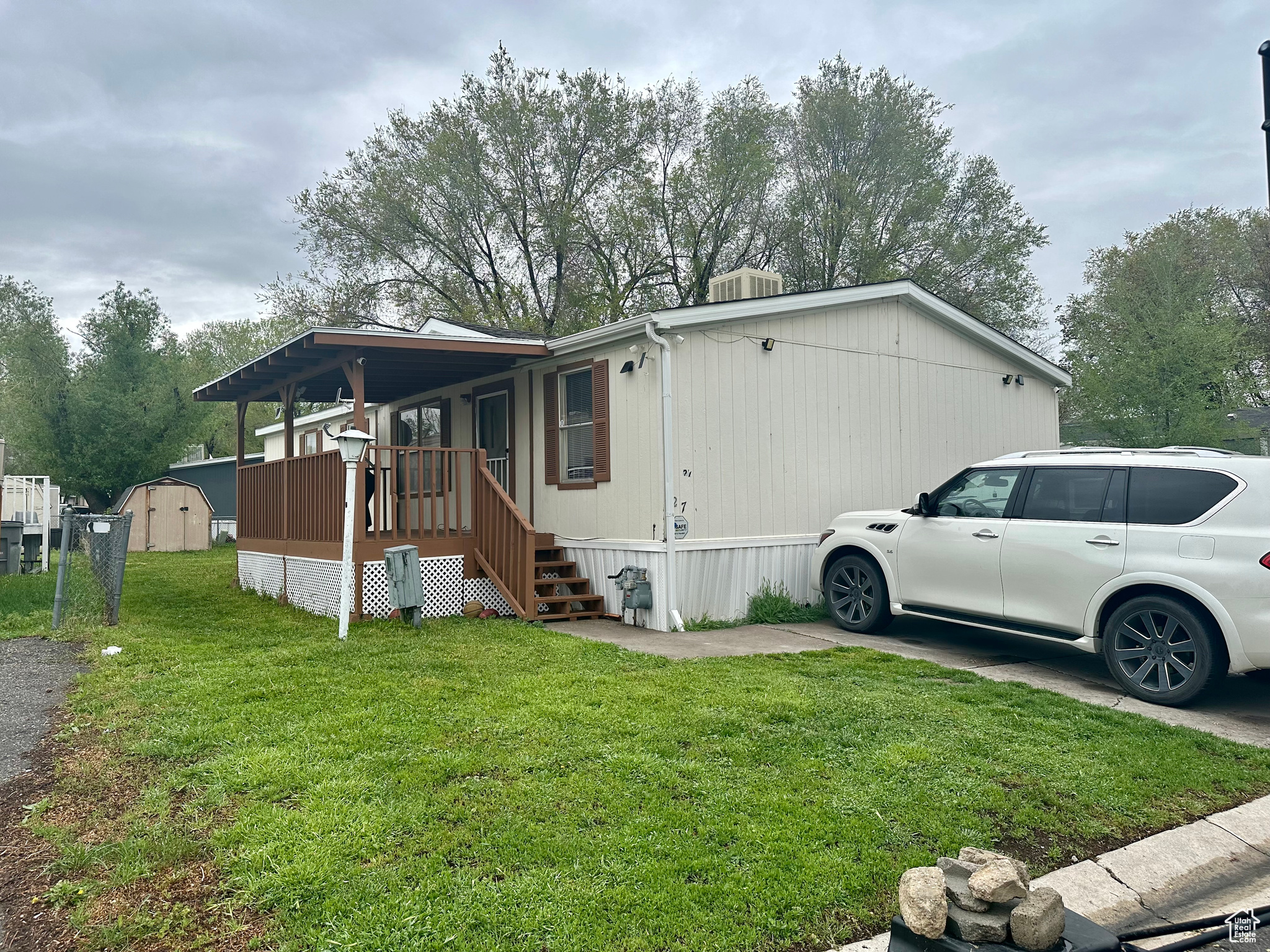 View of front of property featuring a front lawn and a storage shed