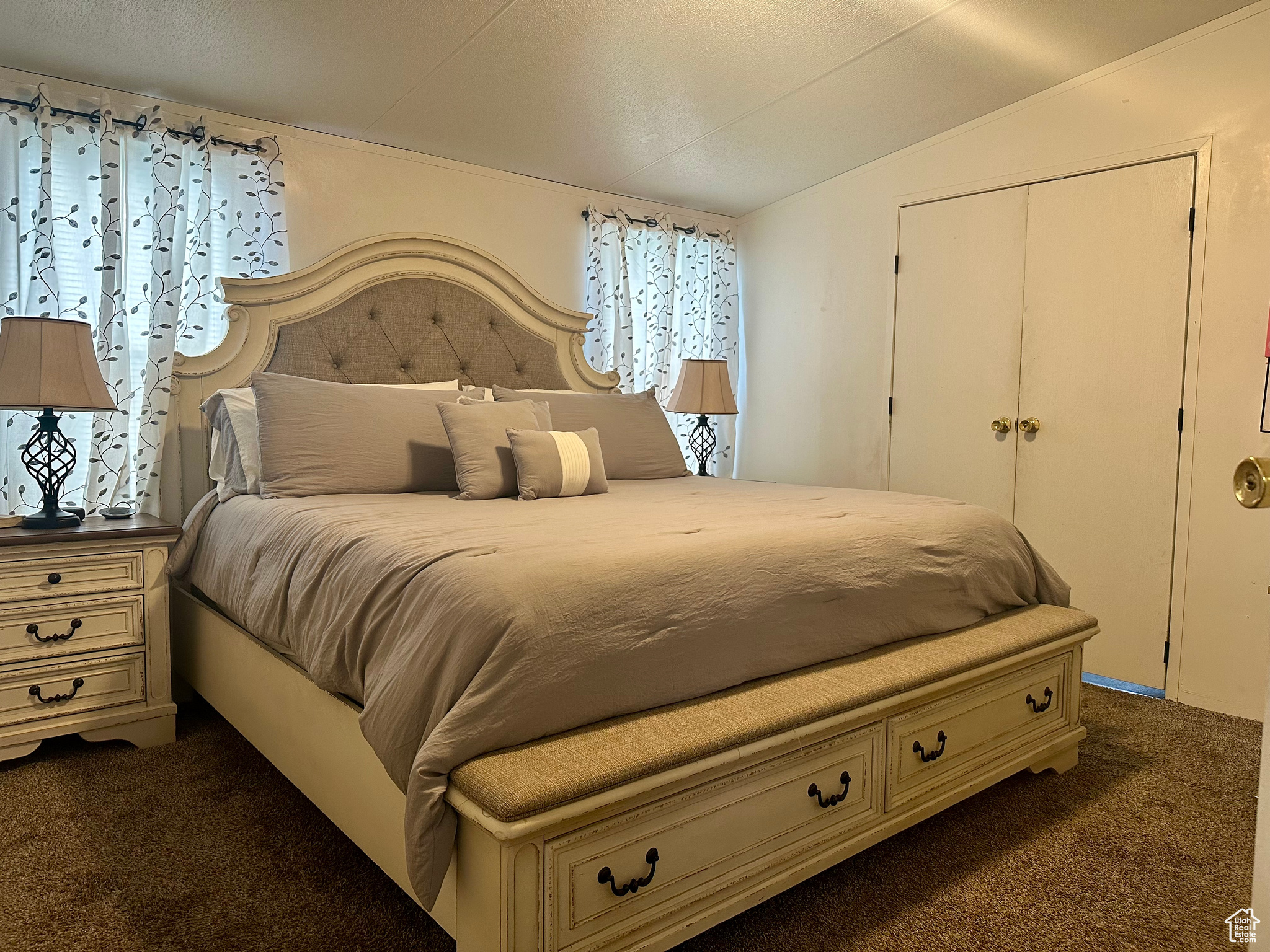 Carpeted bedroom featuring a closet and vaulted ceiling