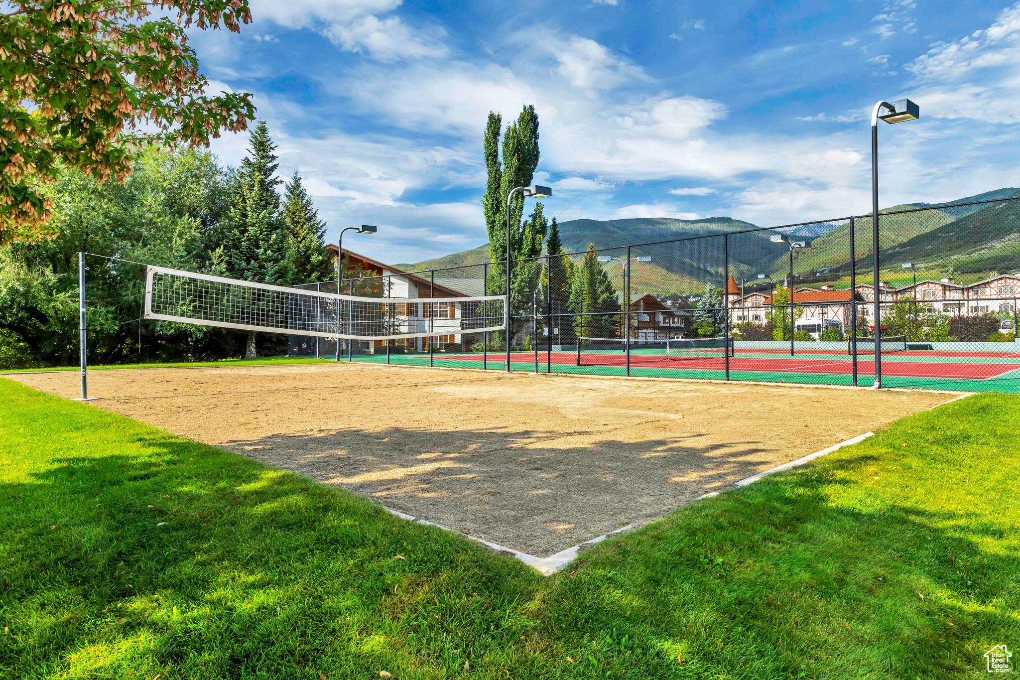 View of home's community featuring volleyball court, a mountain view, and a yard