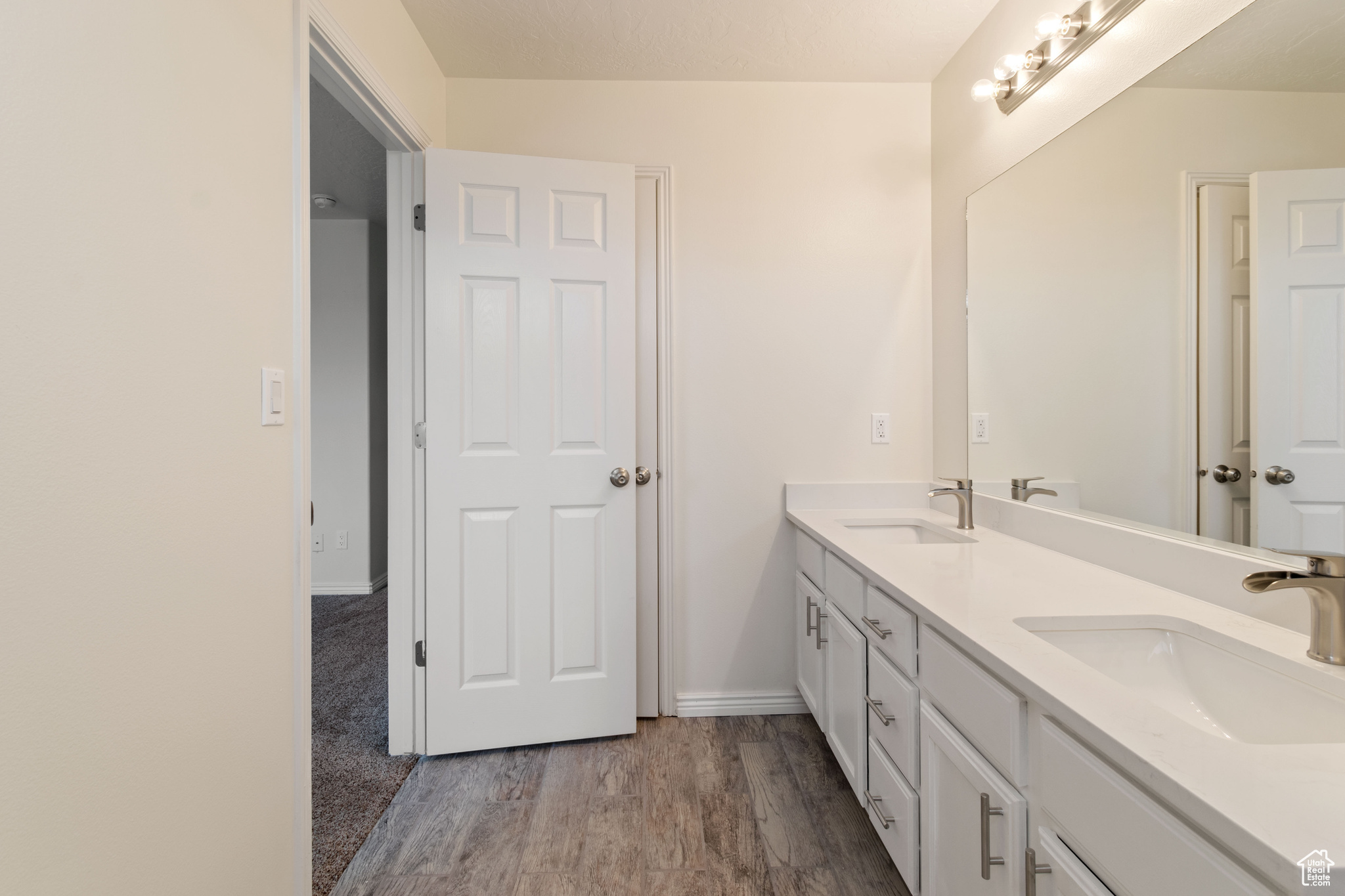 Bathroom featuring hardwood / wood-style floors and dual vanity