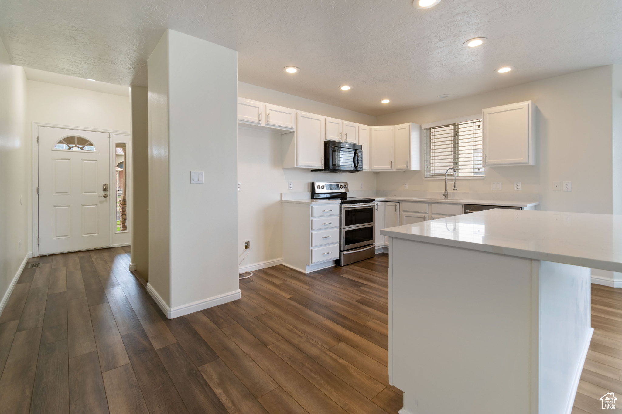 Kitchen featuring sink, white cabinetry, dark hardwood / wood-style floors, and double oven range