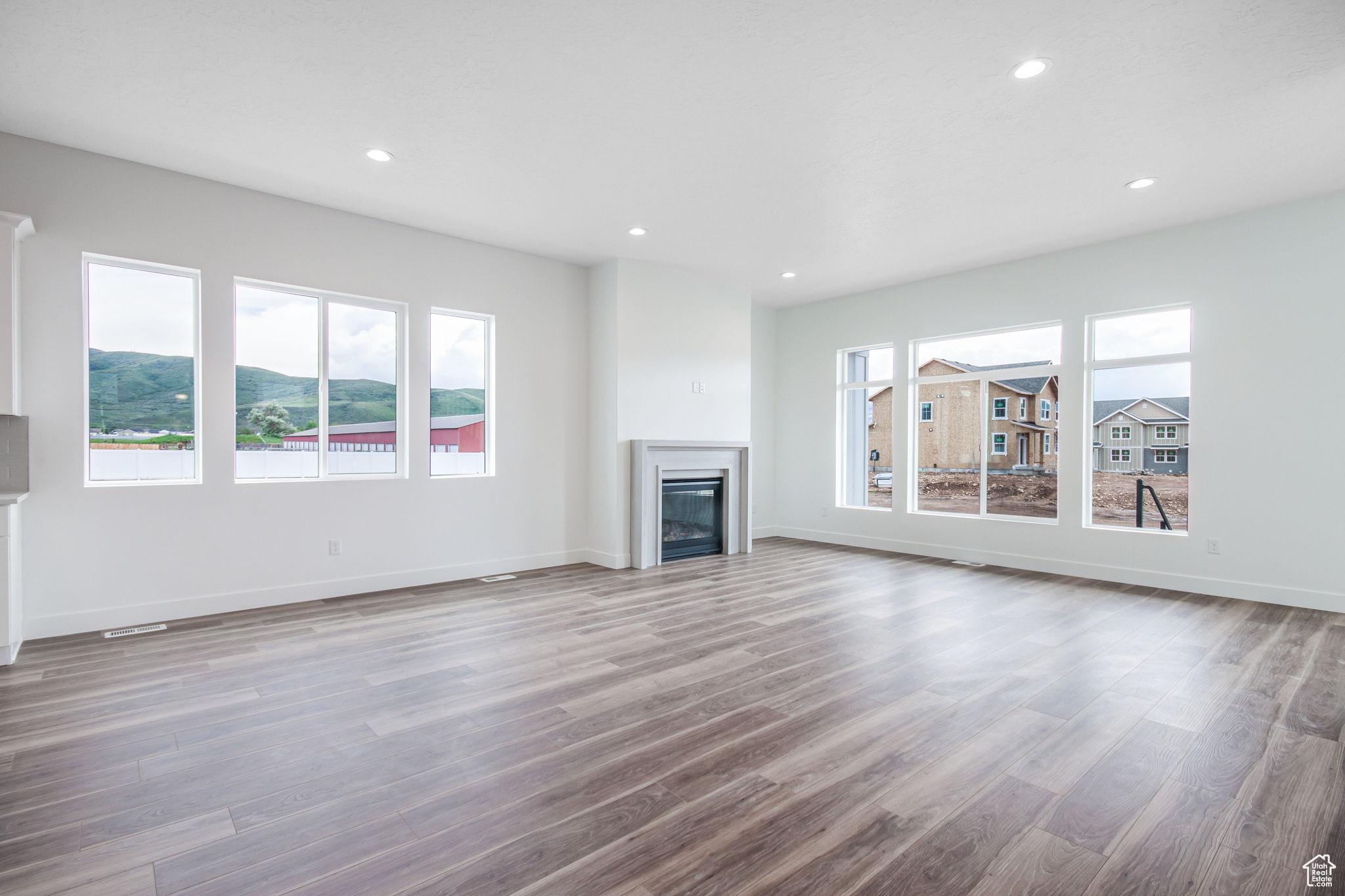 Unfurnished living room with a wealth of natural light and hardwood / wood-style floors