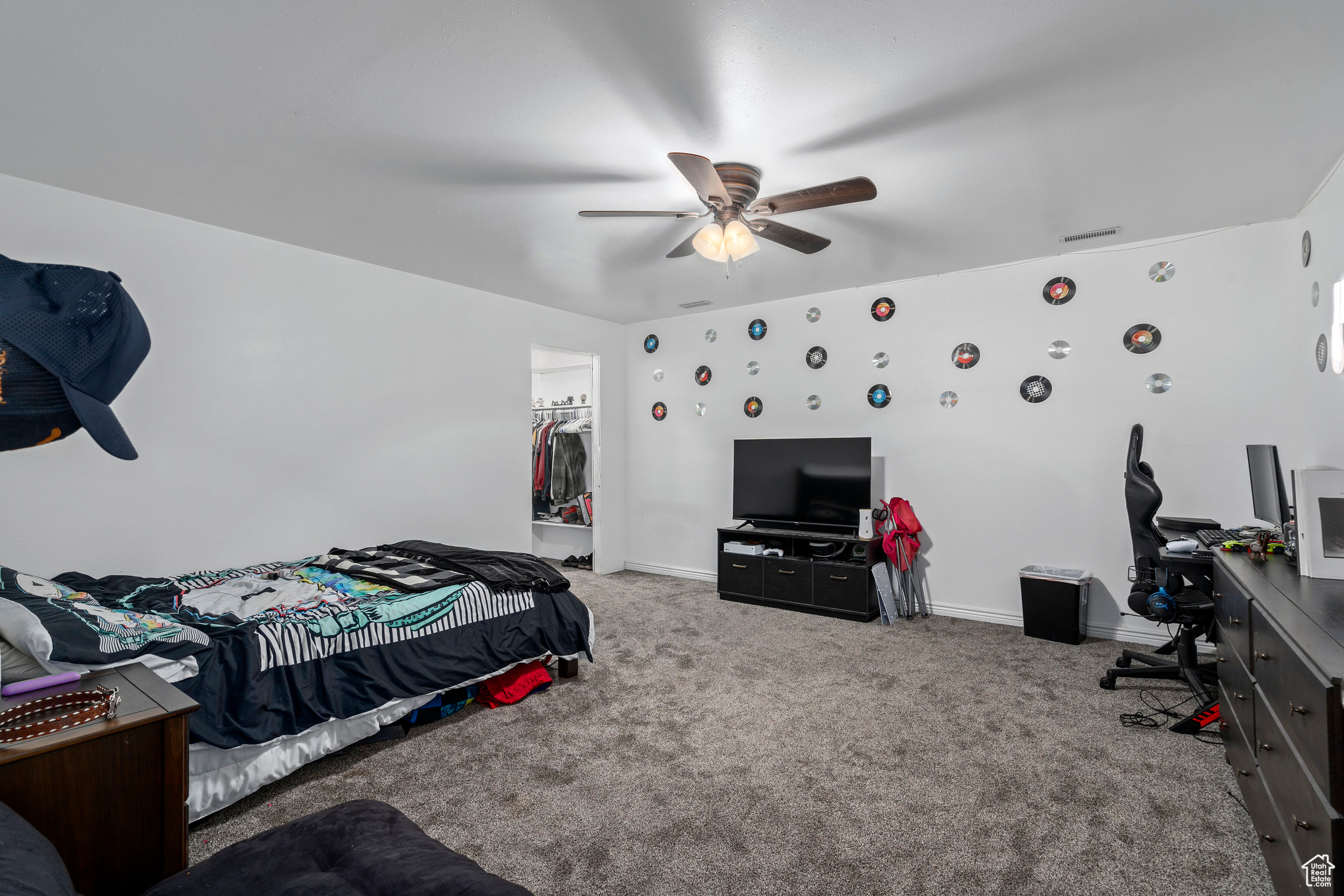 Bedroom with a closet, a spacious closet, carpet floors, and ceiling fan