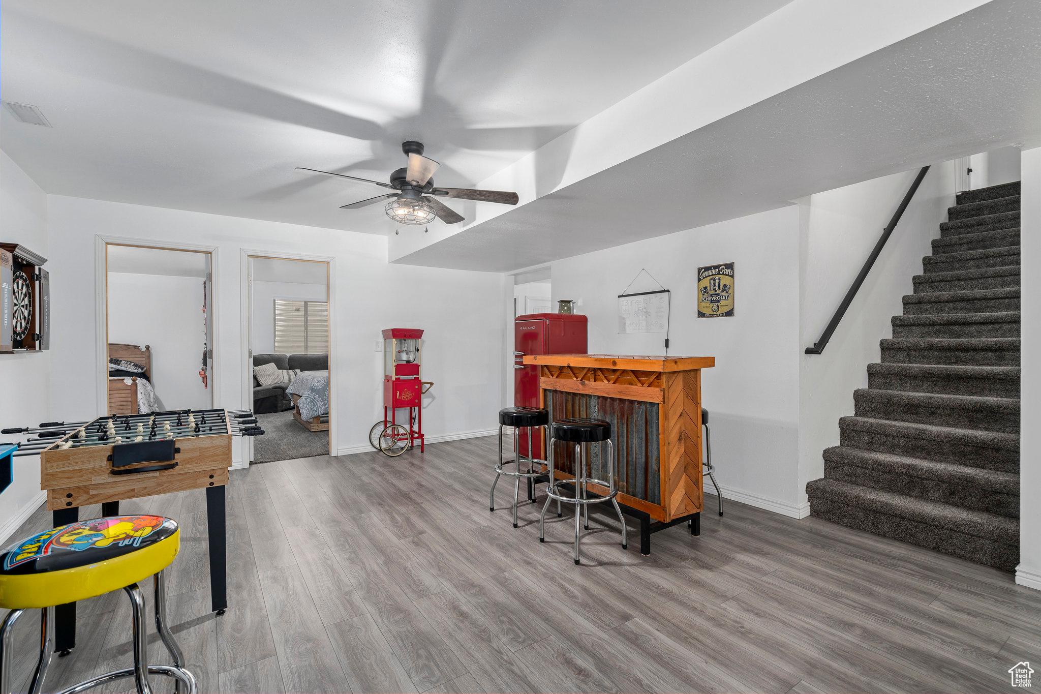 Interior space with bar, ceiling fan, and hardwood / wood-style floors