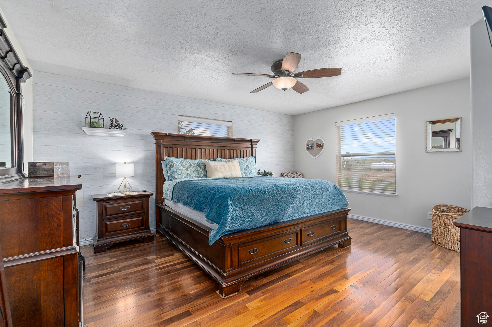 Bedroom with dark hardwood / wood-style floors, ceiling fan, and a textured ceiling