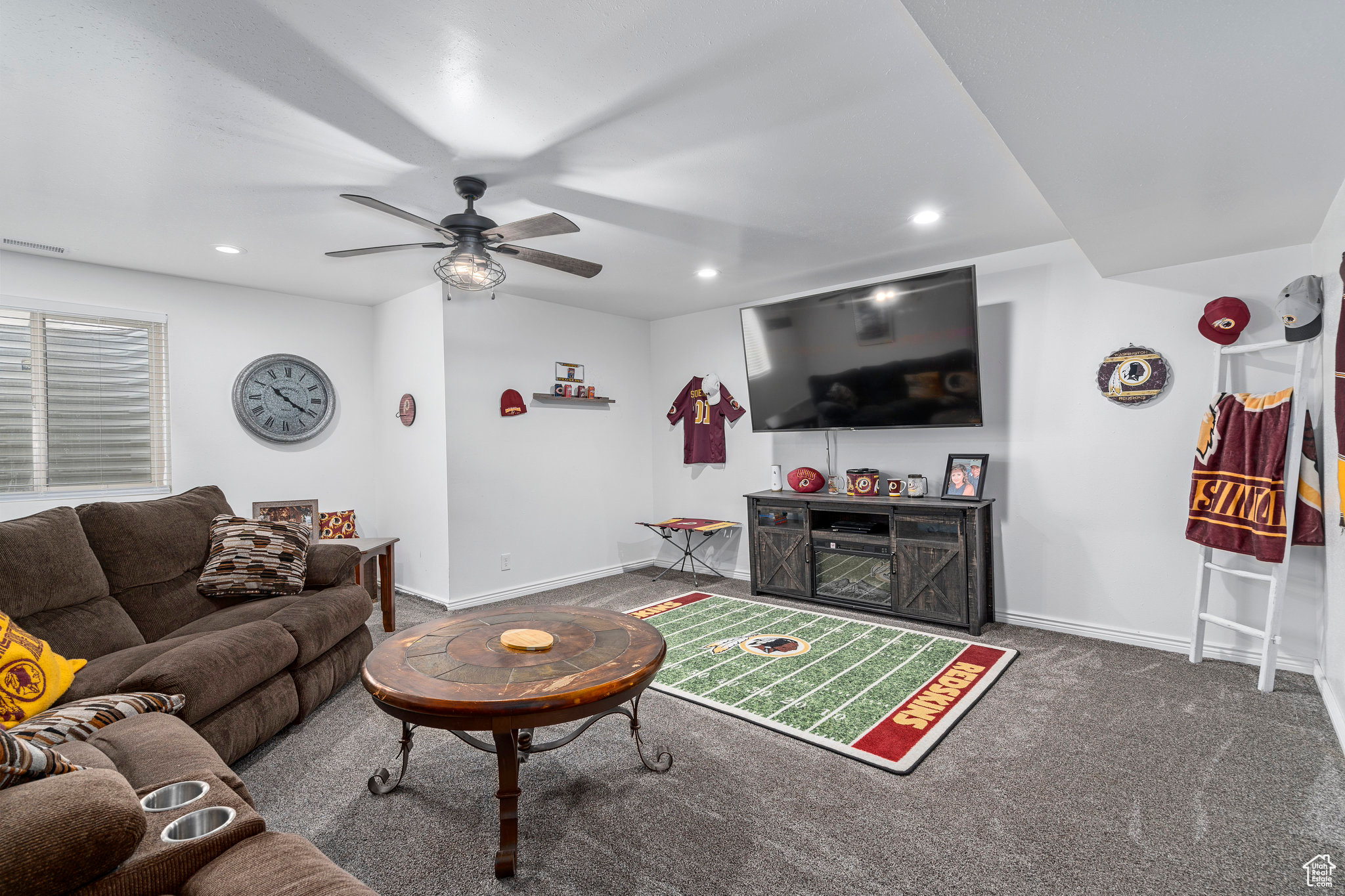 Carpeted living room featuring ceiling fan