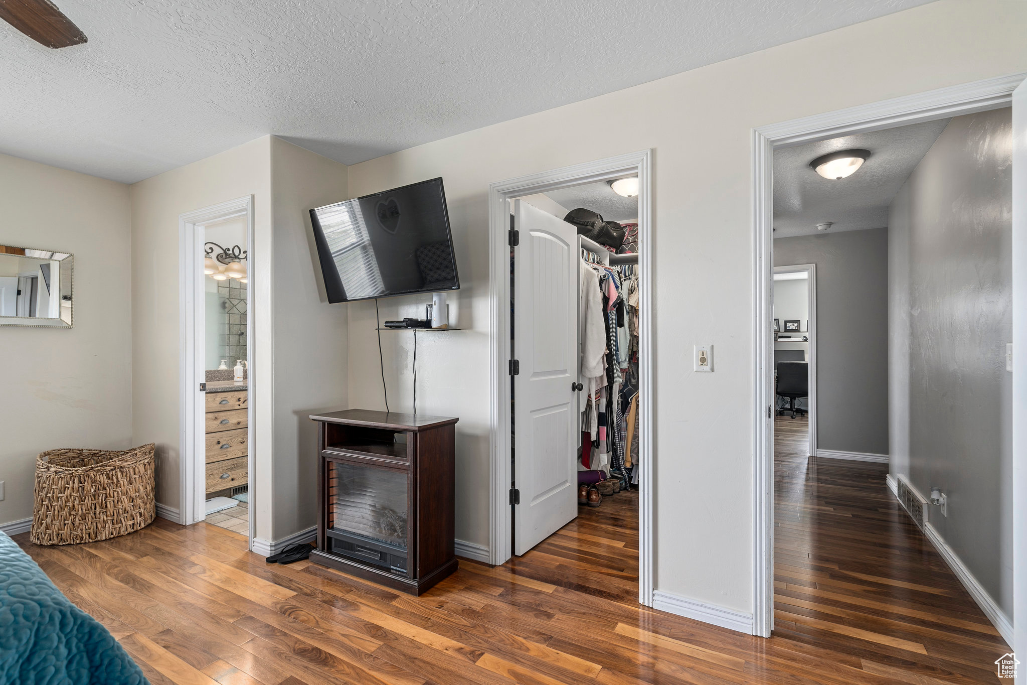 Interior space featuring dark wood-type flooring and a textured ceiling