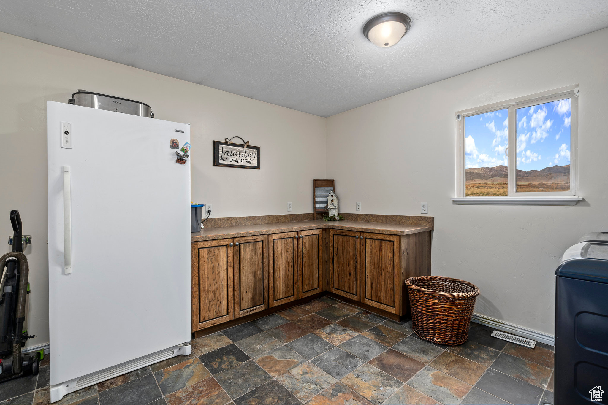 Interior space featuring dark tile flooring and a textured ceiling