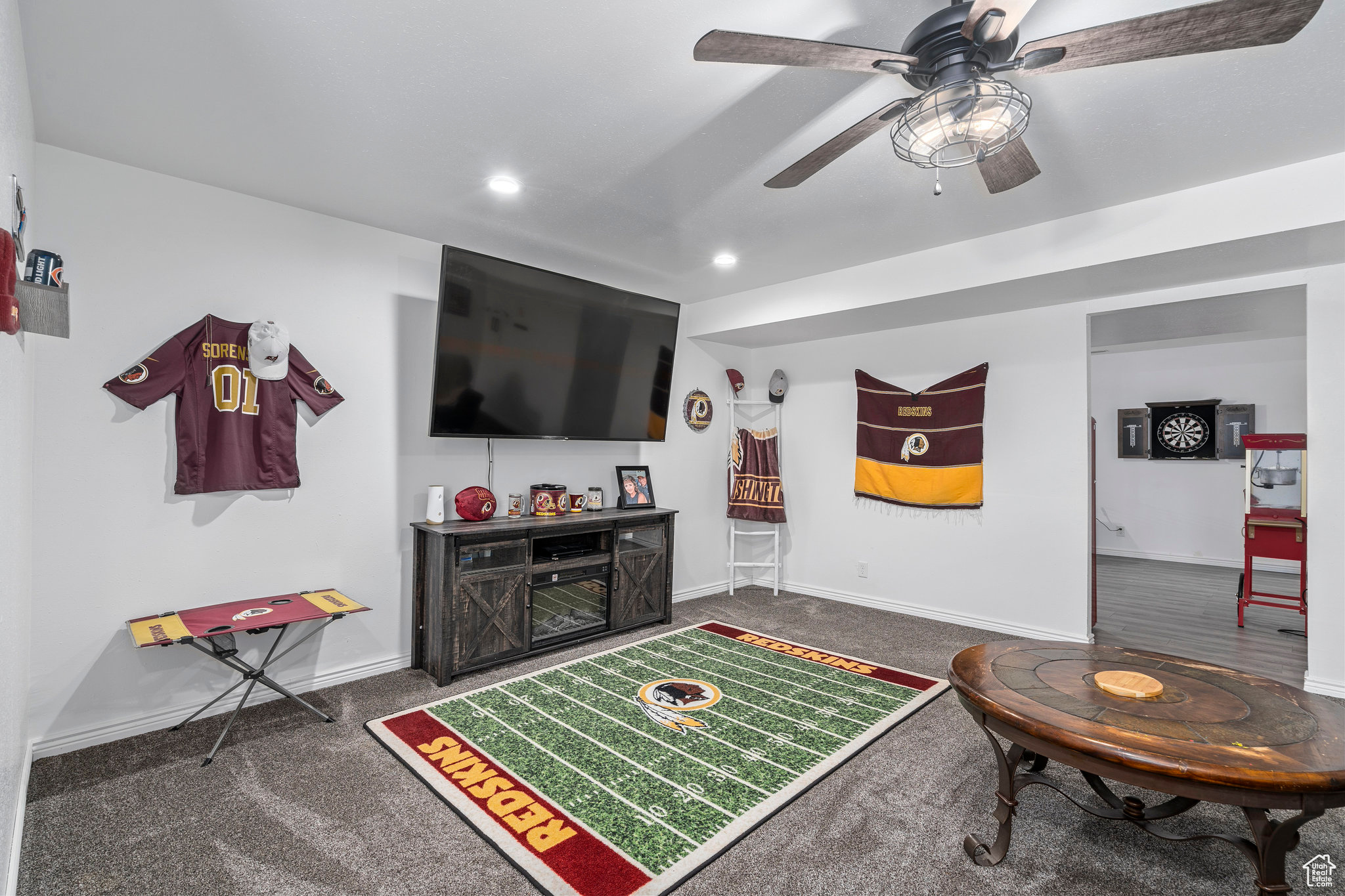 Living room with ceiling fan and dark carpet