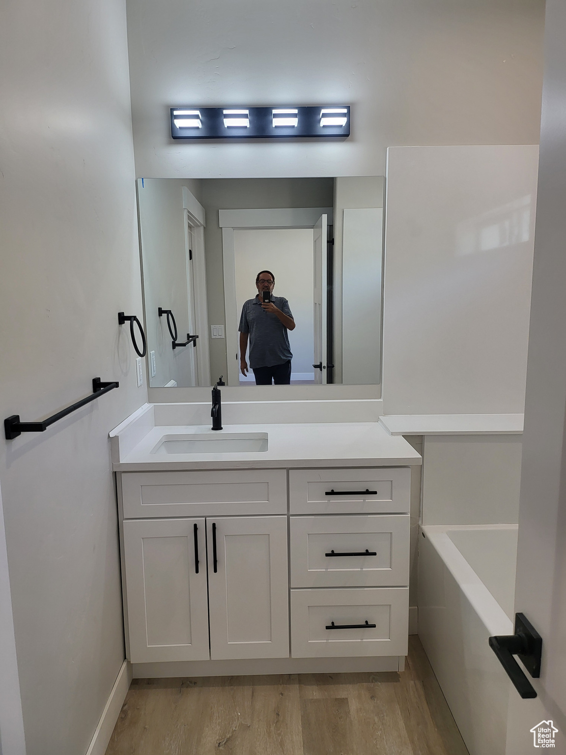 Master Bathroom with a tub to relax in, vanity, and hardwood / wood-style floors