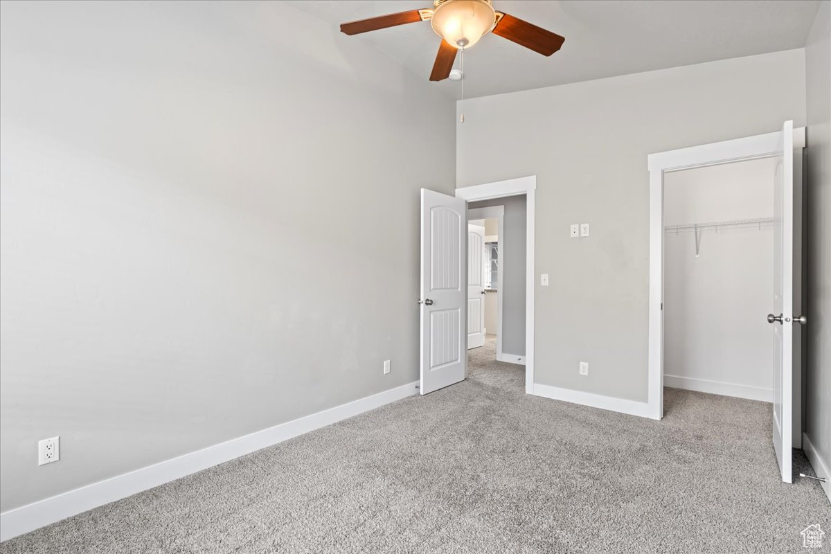 Unfurnished bedroom featuring carpet flooring, a closet, and ceiling fan