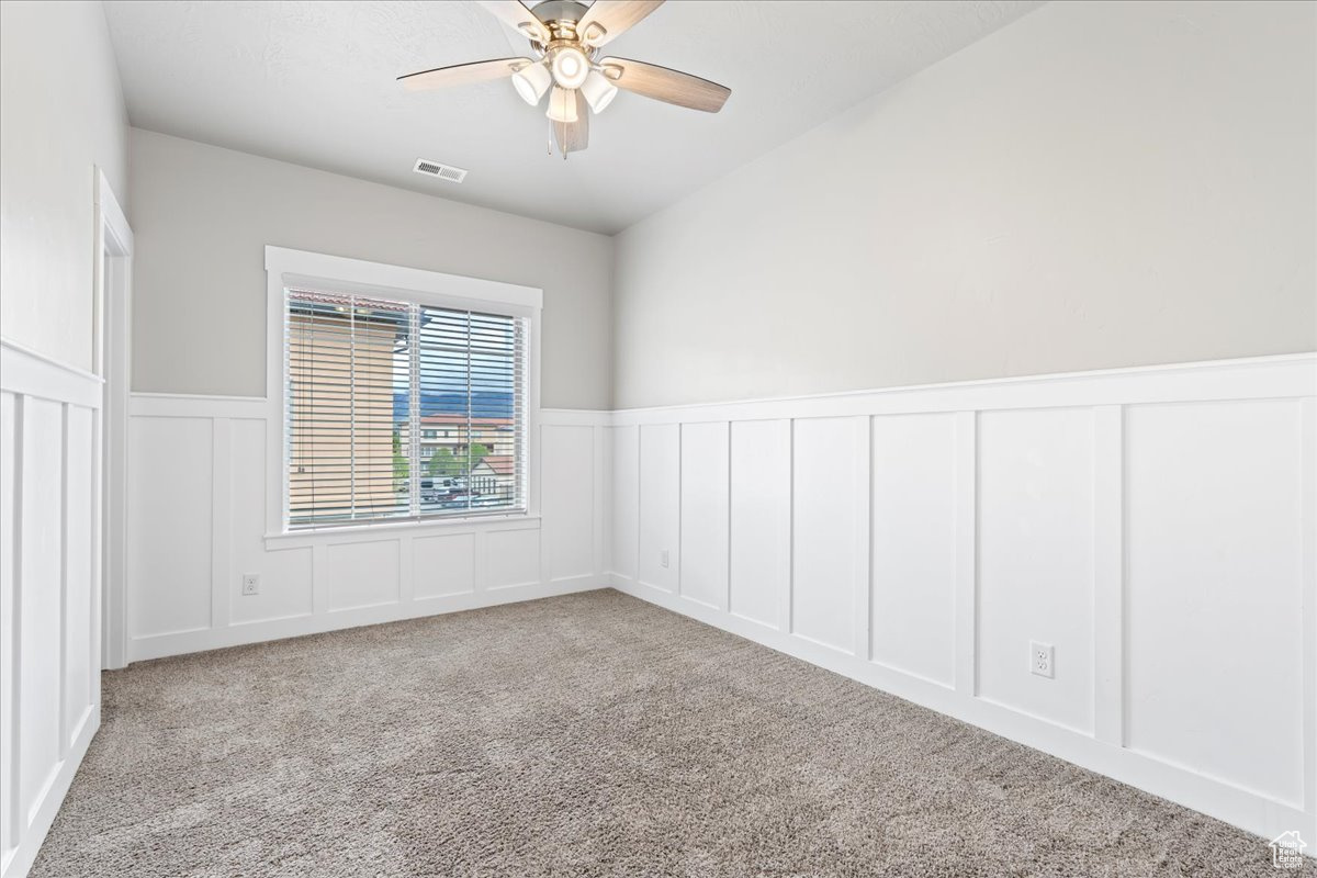 Spare room with light colored carpet and ceiling fan