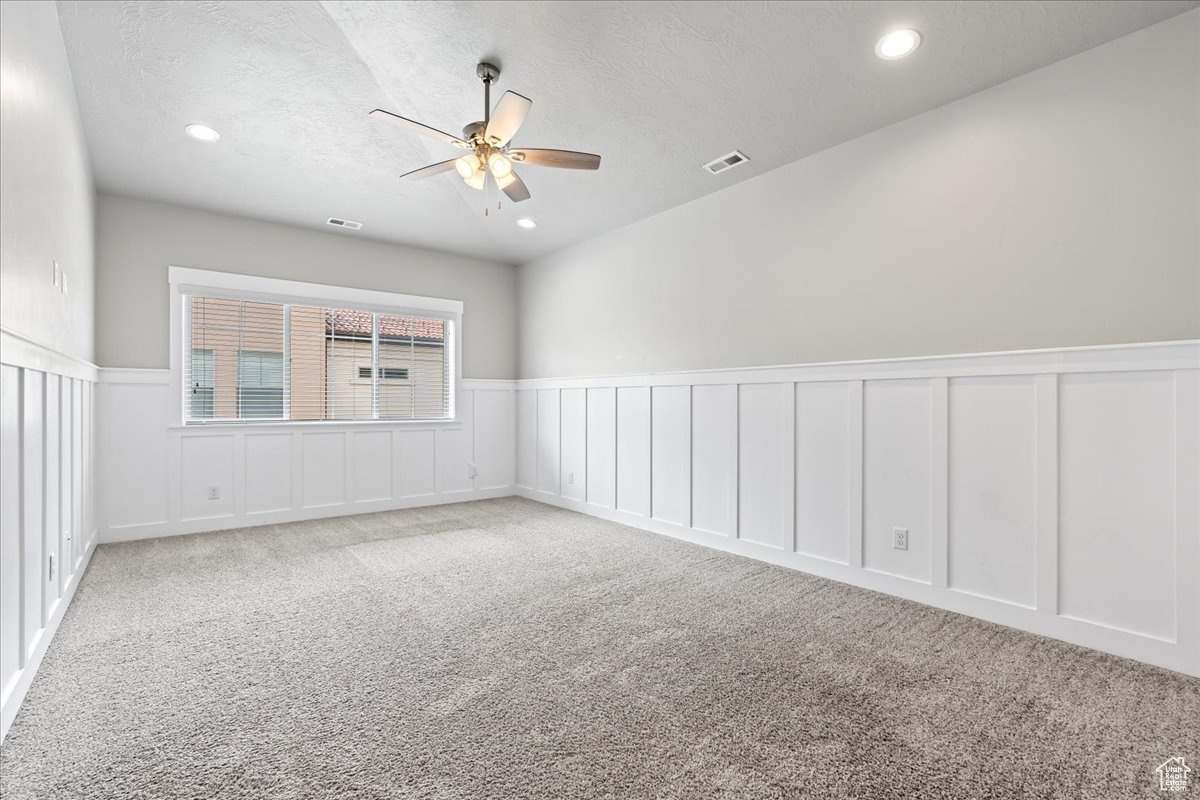 Spare room featuring ceiling fan and light carpet