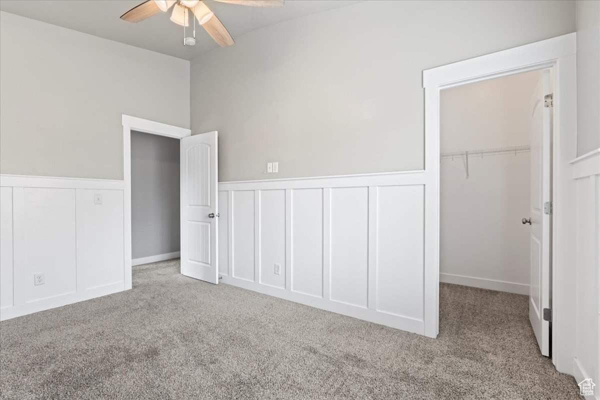 Unfurnished bedroom featuring light colored carpet, ceiling fan, and a closet