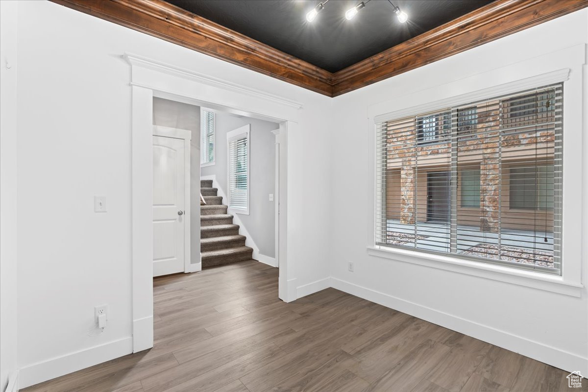 Unfurnished room with hardwood / wood-style floors and track lighting