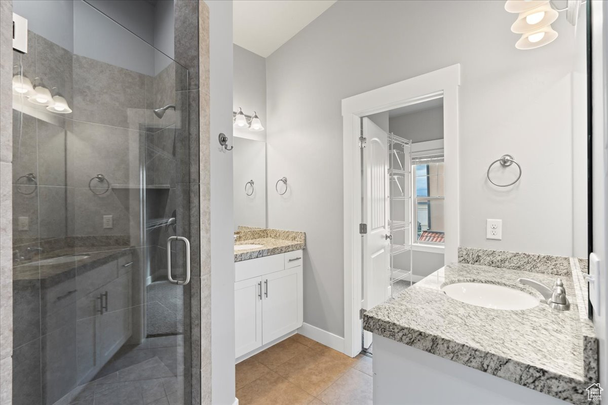 Bathroom featuring a shower with door, tile floors, and large vanity