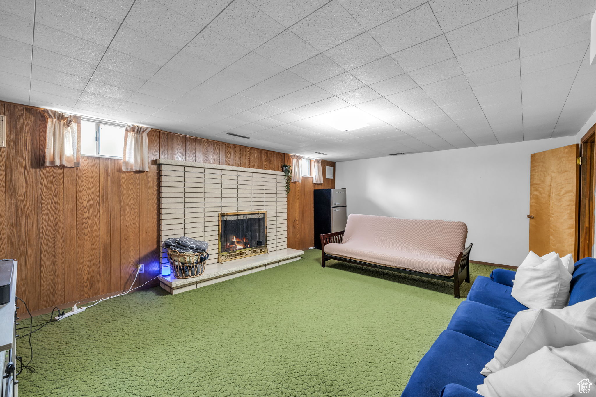 Unfurnished living room with wooden walls, a fireplace, and carpet floors