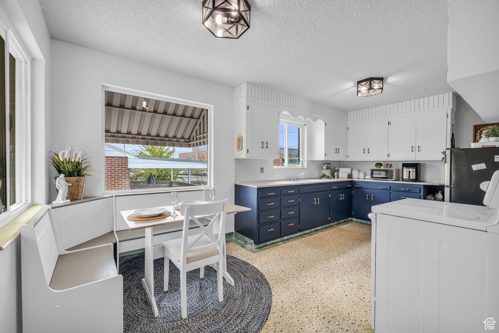 Kitchen with blue cabinets, a healthy amount of sunlight, and a textured ceiling