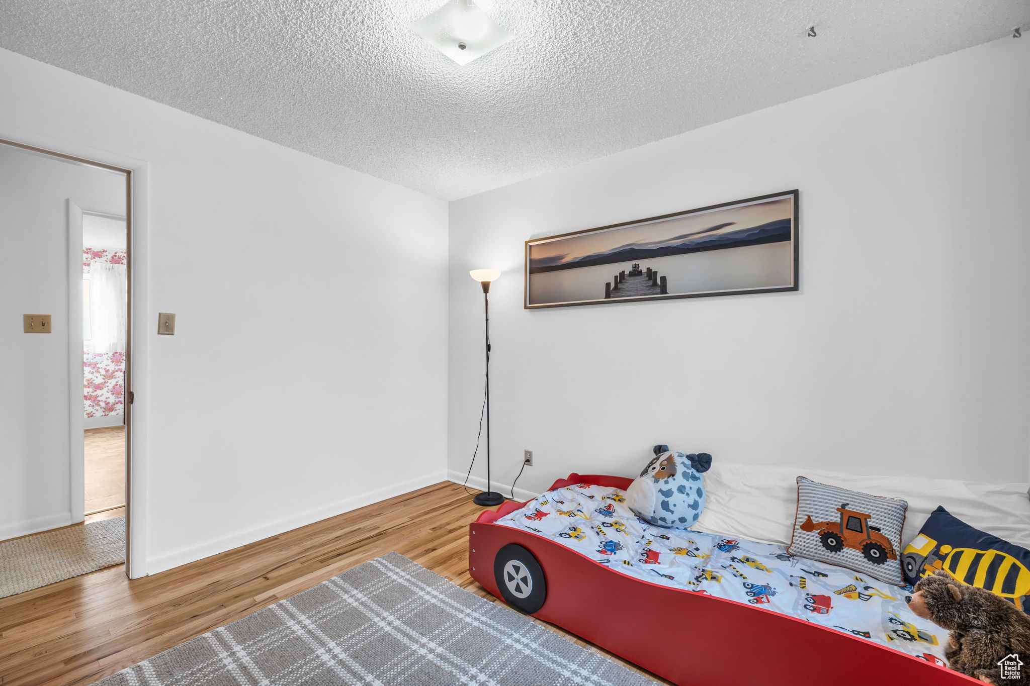 Bedroom with hardwood / wood-style flooring and a textured ceiling