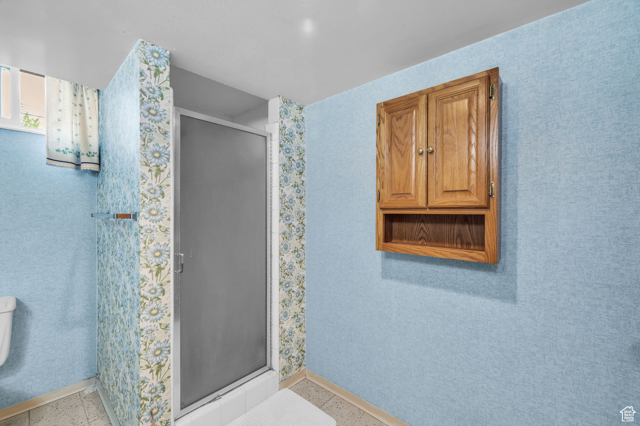 Bathroom featuring walk in shower, toilet, and tile floors