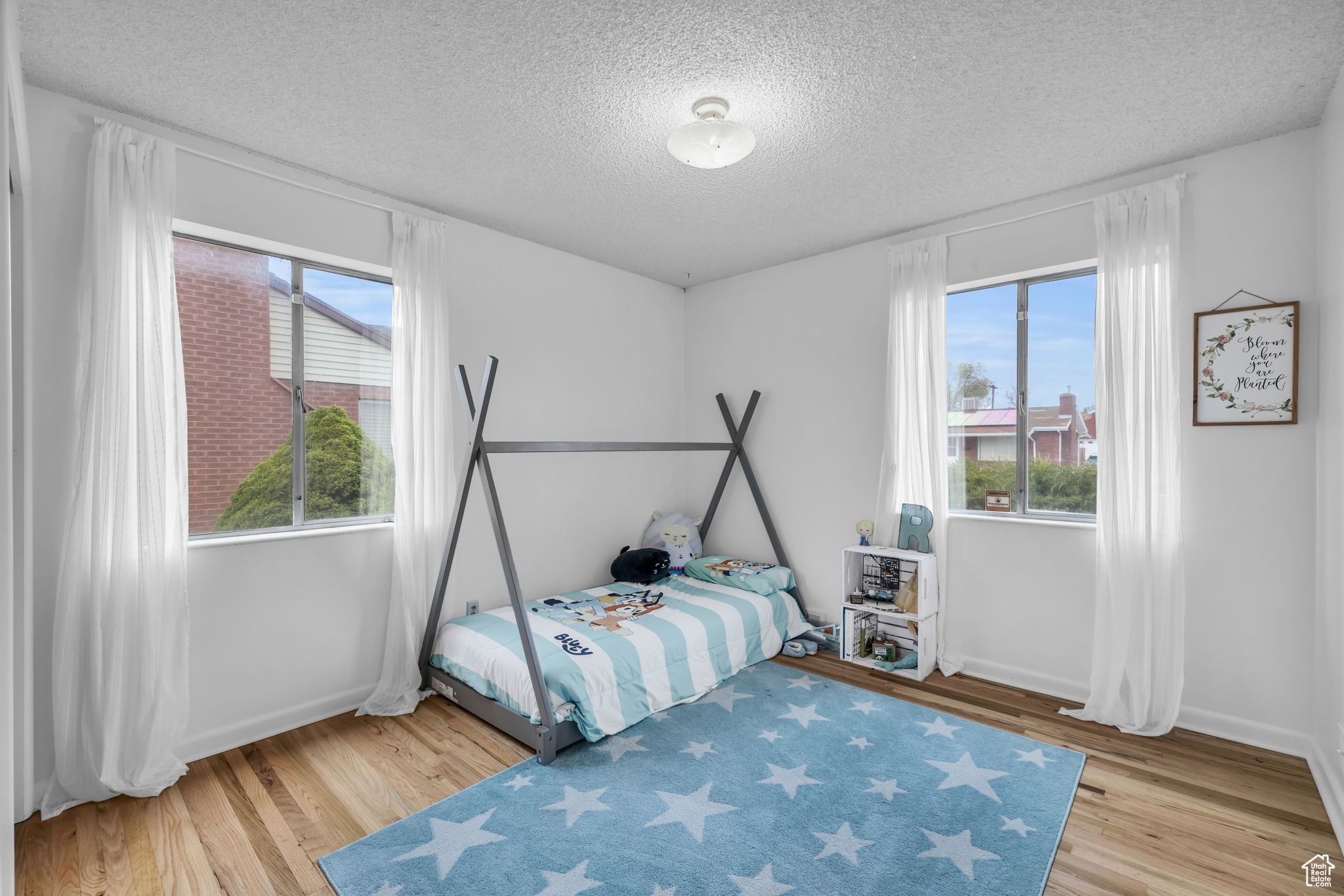 Bedroom with light hardwood / wood-style flooring and a textured ceiling