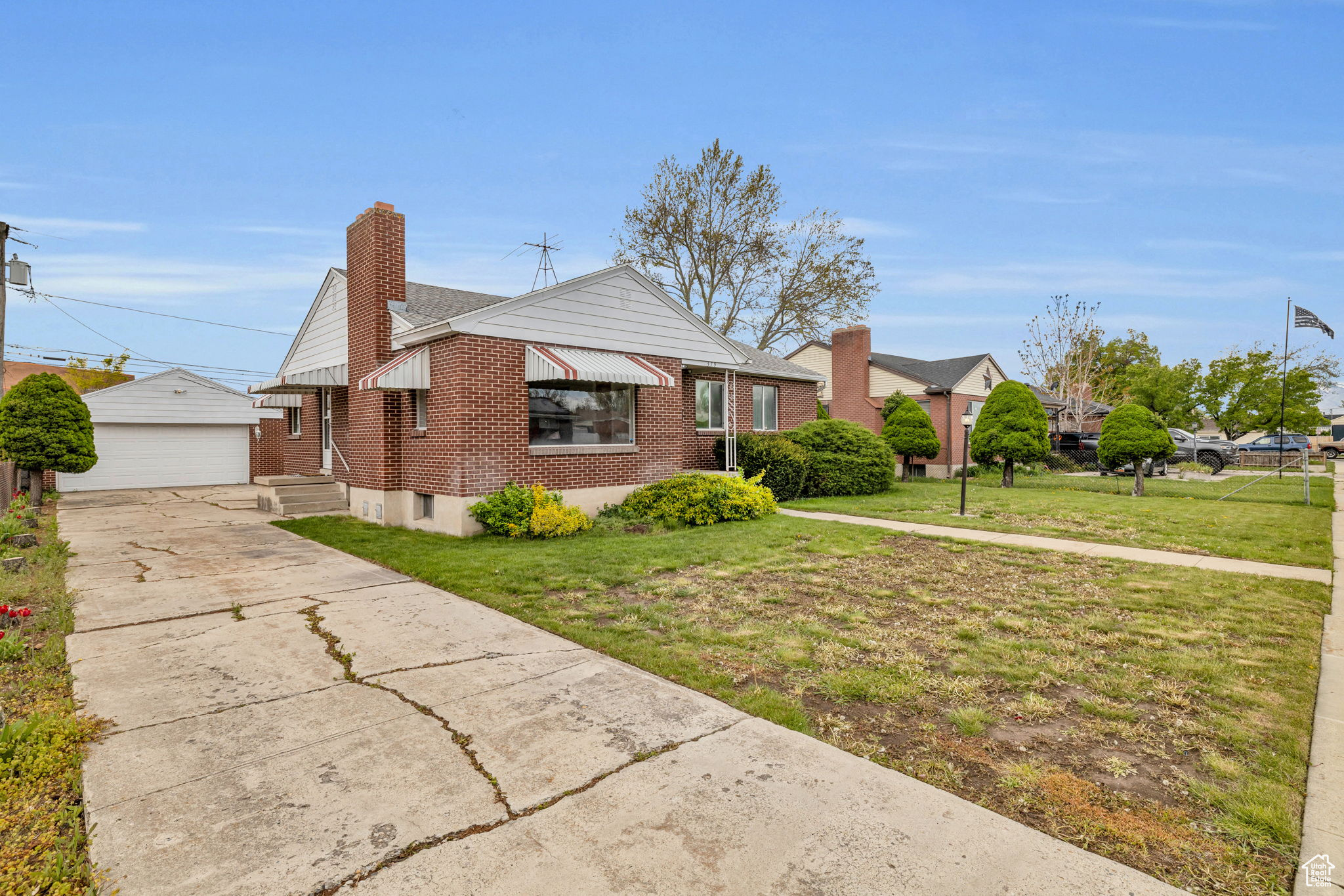 View of front of house featuring an outdoor structure, a garage, and a front lawn