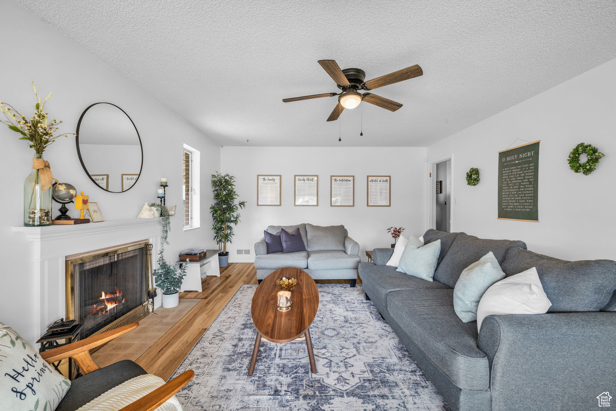 Living room with wood-type flooring, ceiling fan, and a textured ceiling