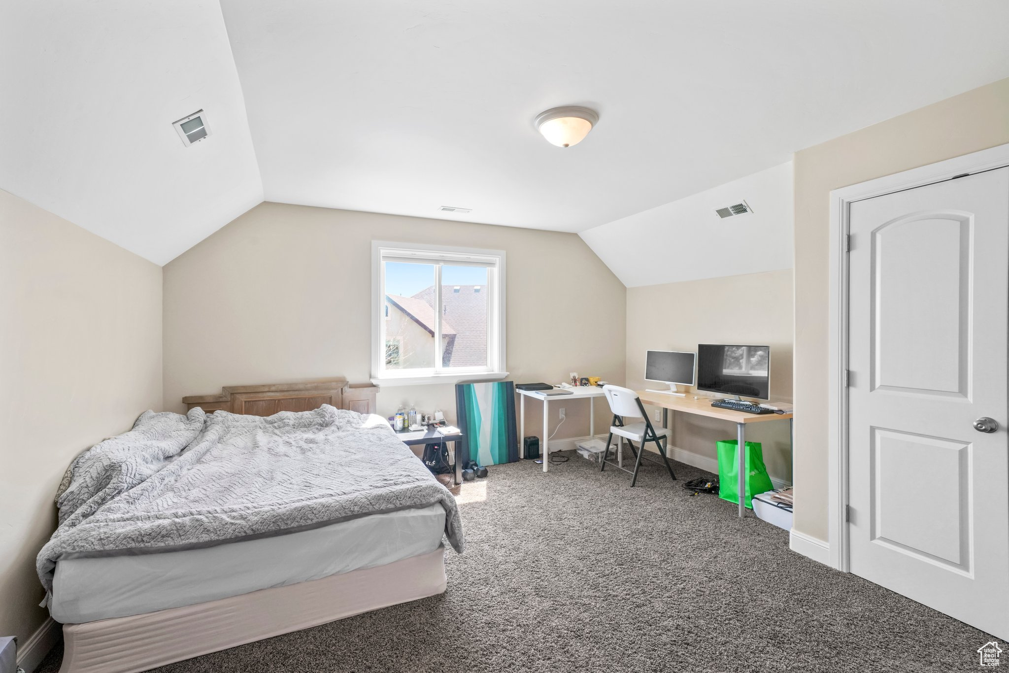 Carpeted bedroom with lofted ceiling