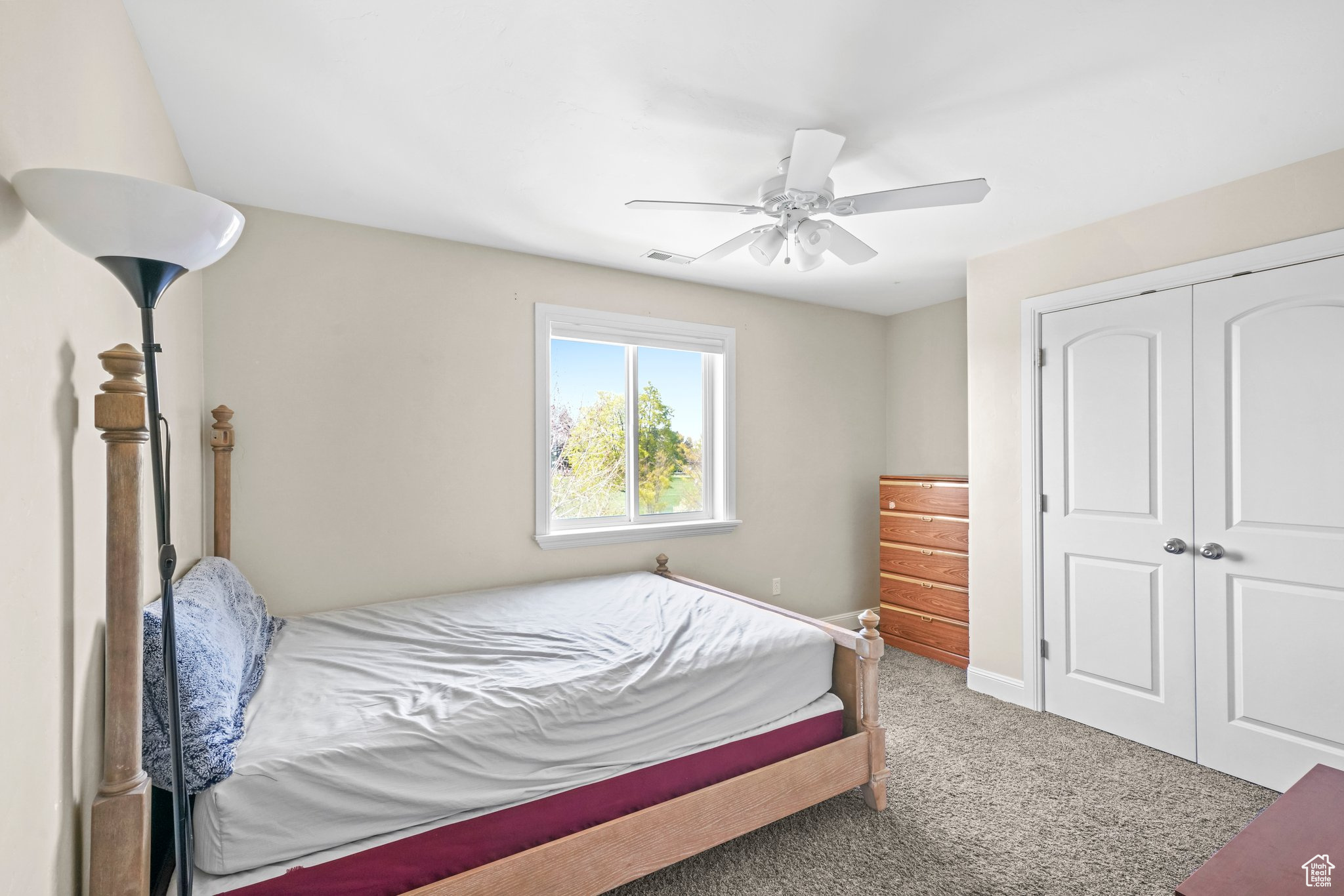 Carpeted bedroom with a closet and ceiling fan