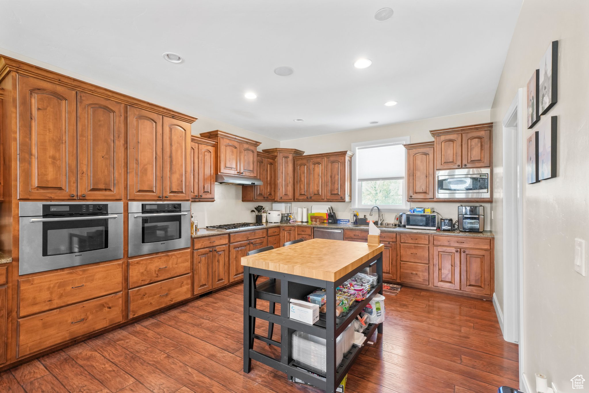 Kitchen featuring stainless steel appliances and dark hardwood / wood-style flooring