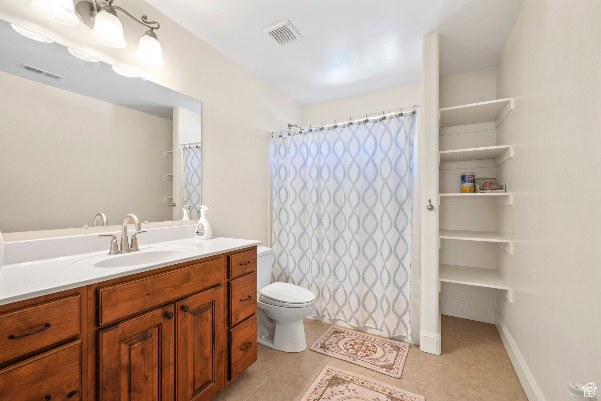 Bathroom with toilet, tile floors, and vanity