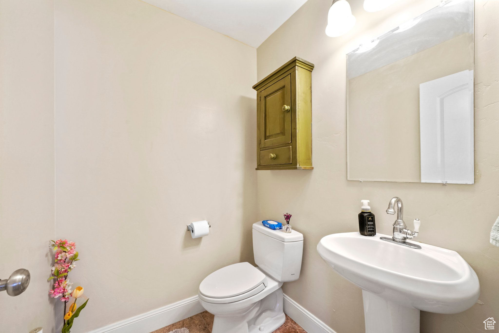 Bathroom with toilet, tile floors, and sink