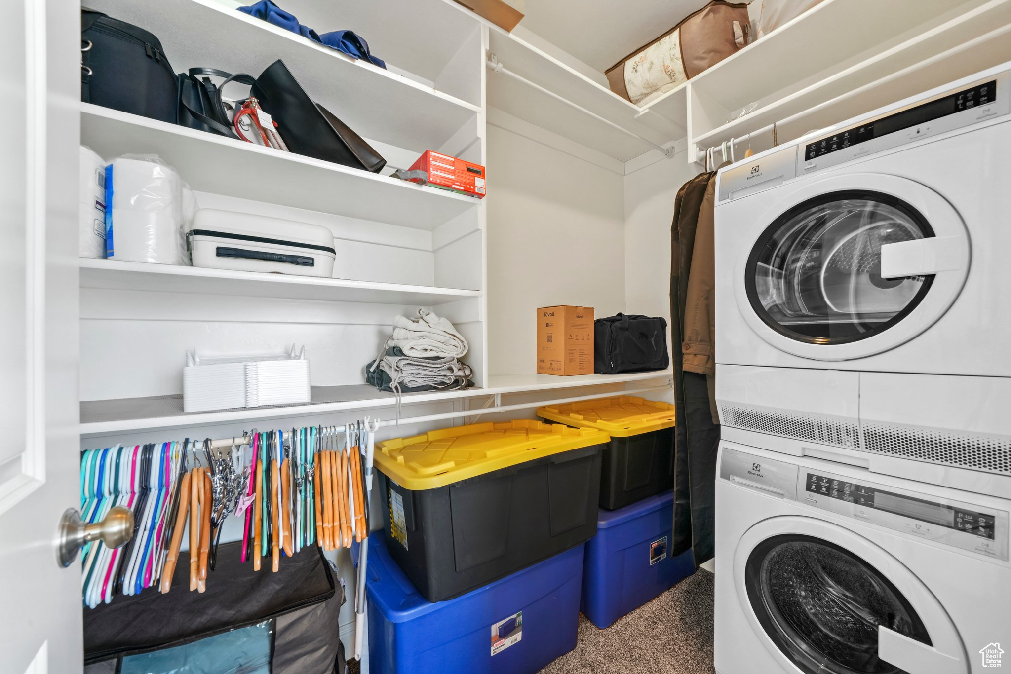 Master Closet laundry area with stacked washer and dryer and carpet floors