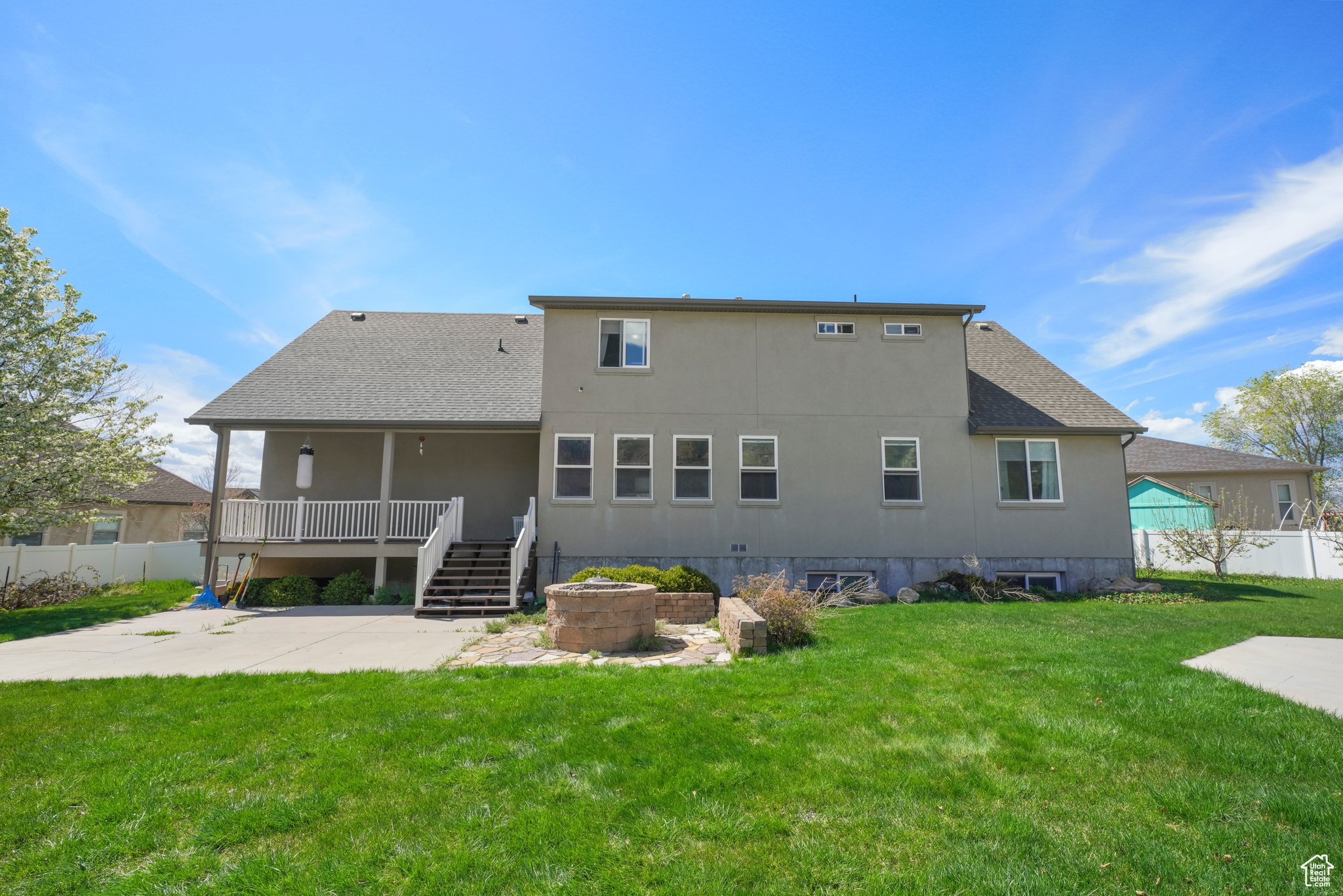 Back of property featuring a patio area, a deck, and a lawn