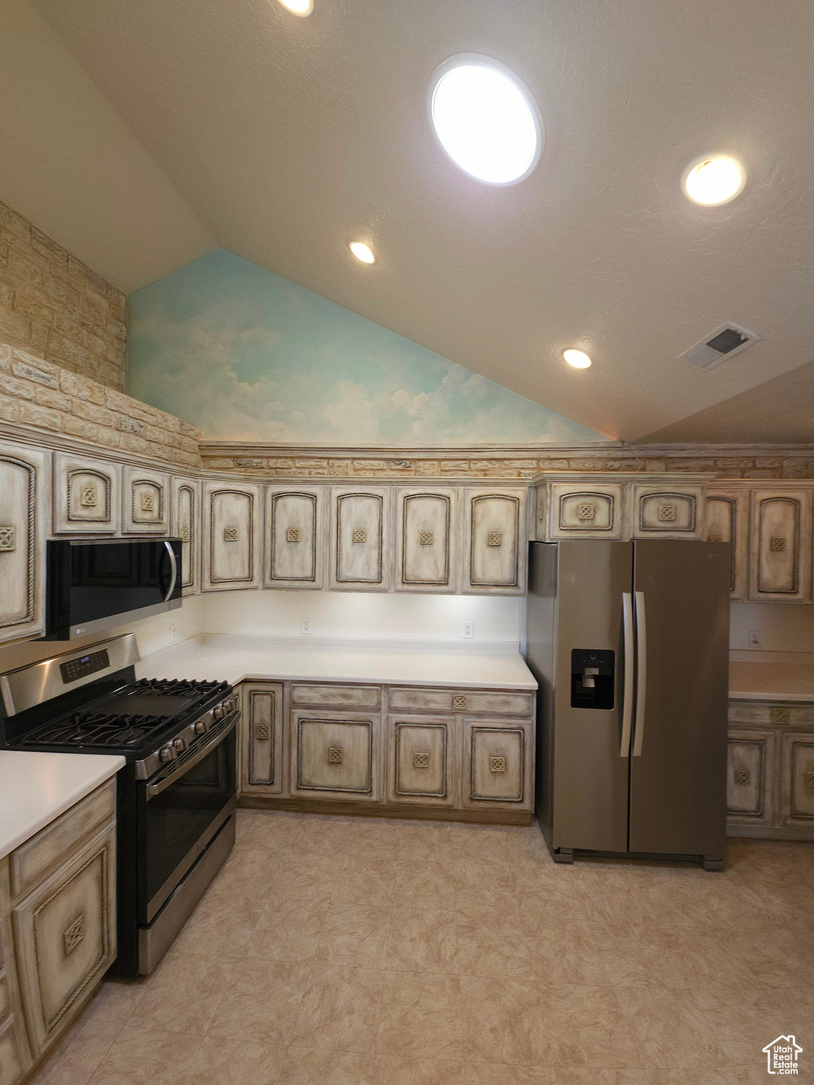 Custom hand-finished cabinets continue the elegance into the kitchen, nestled under a hand-painted sky and clouds mural.