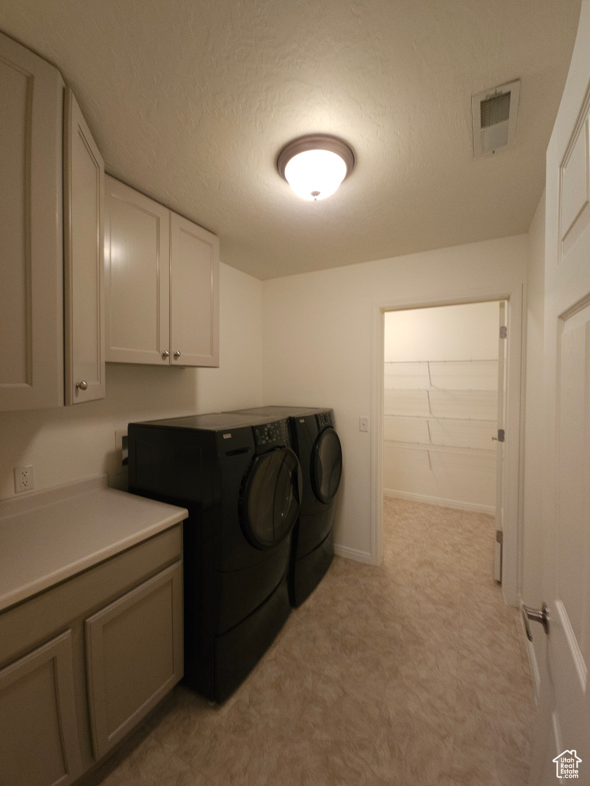 washer and dryer included in this laundry room, with freshly painted cabinets.