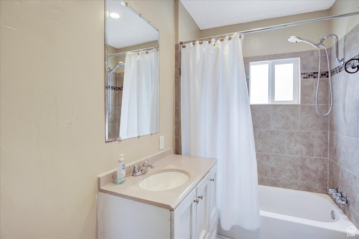 Bathroom with shower / bath combination with curtain and large vanity