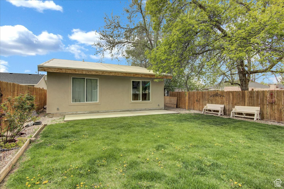 Rear view of property featuring a patio and a lawn