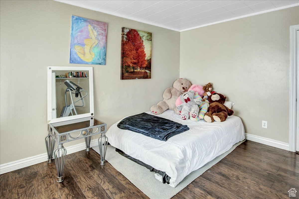 Bedroom featuring ornamental molding and dark wood-type flooring