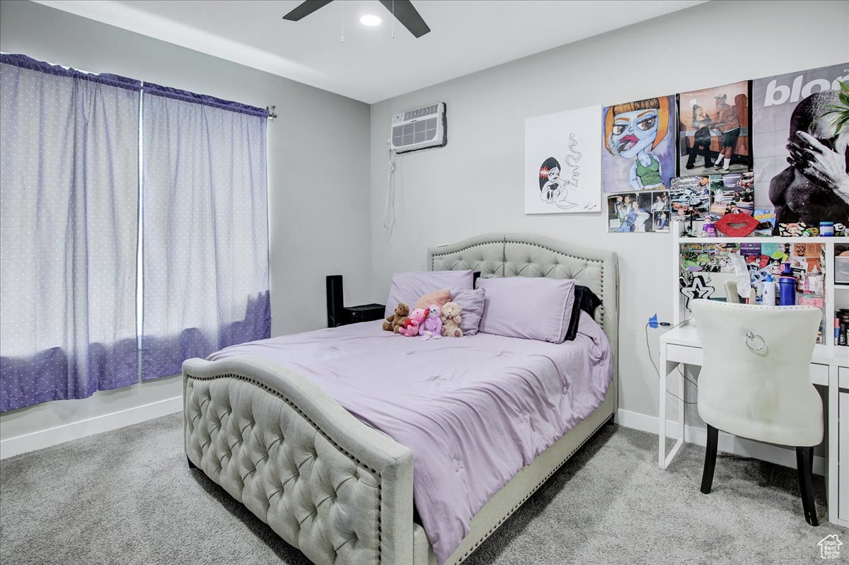 Bedroom featuring ceiling fan, carpet, and a wall unit AC