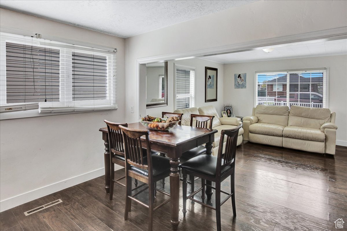 Dining area with dark hardwood / wood-style floors and a textured ceiling