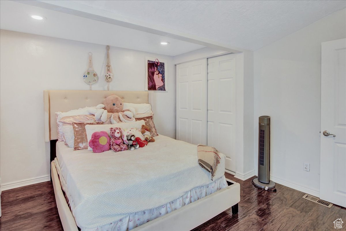 Bedroom featuring a closet and dark wood-type flooring