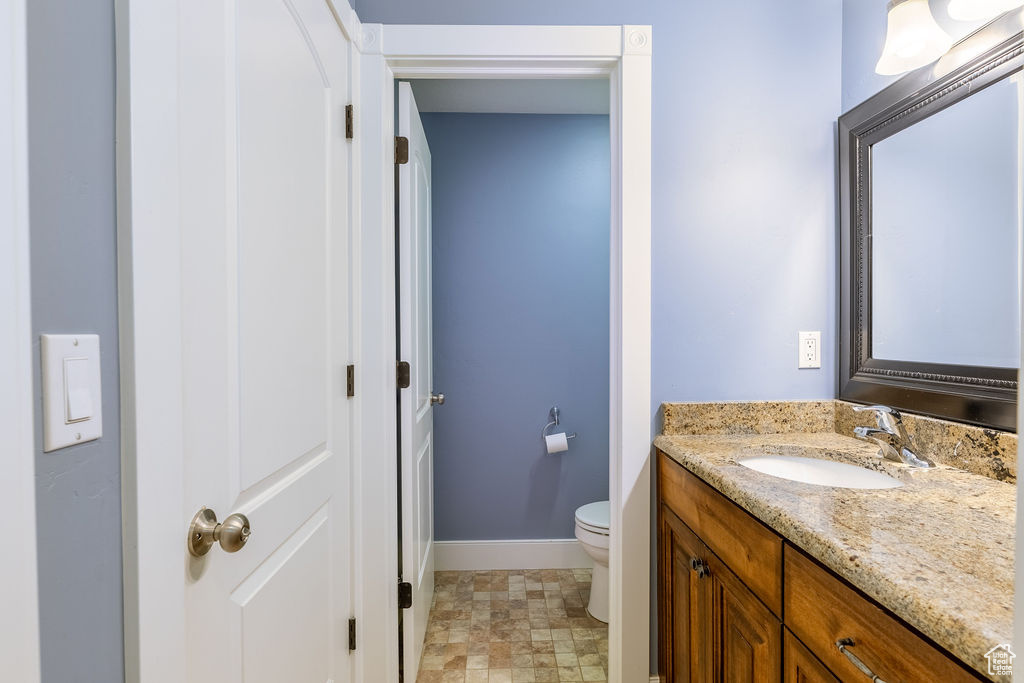 Bathroom featuring tile flooring, oversized vanity, and toilet