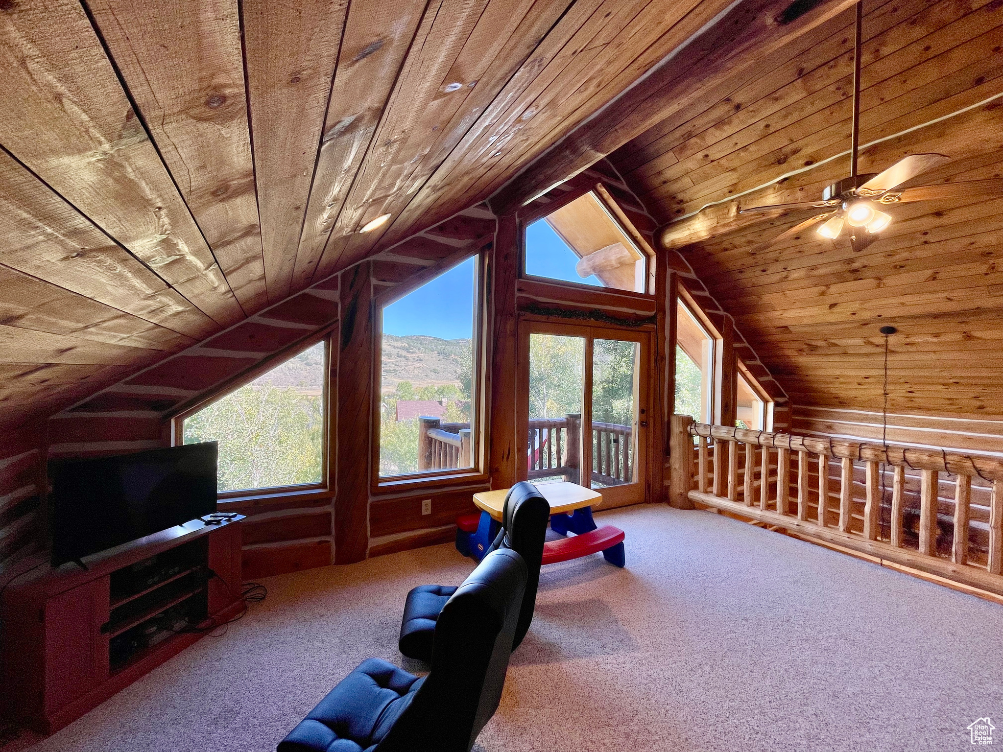Interior space featuring wood ceiling, a healthy amount of sunlight, carpet, and vaulted ceiling
