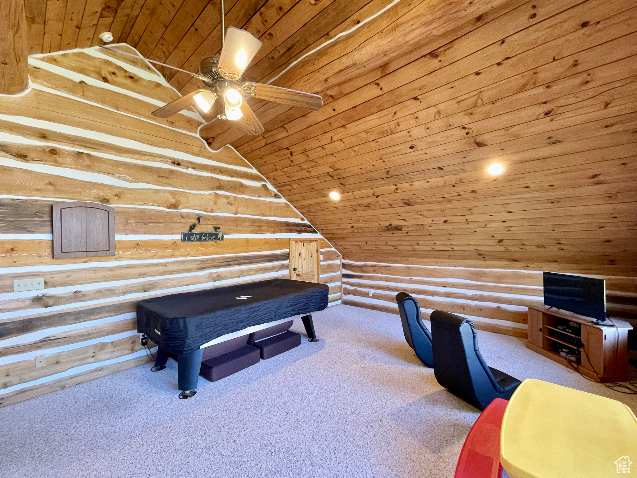 Interior space with log walls, pool table, lofted ceiling, carpet flooring, and wooden ceiling