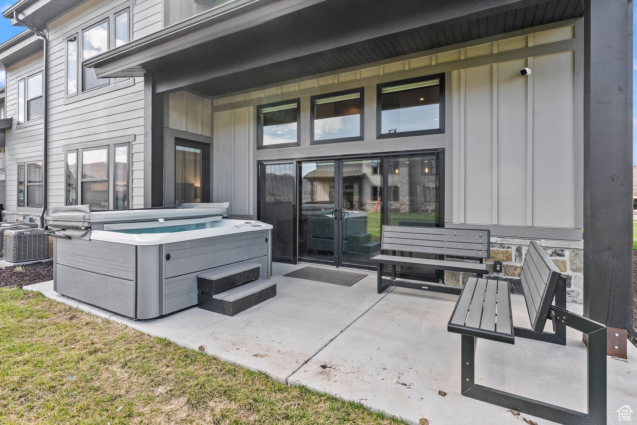 View of patio with a hot tub and central air condition unit